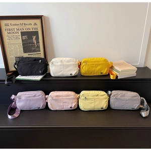Detail of multi-color nylon crossbody bags displayed in a stylish tiered layout