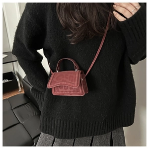 Detailed shot of brick red leopard embossed mini crossbody bag with top handle and strap