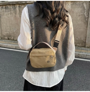 Vue arrière du sac bandoulière beige en nylon avec large sangle réglable en extérieur