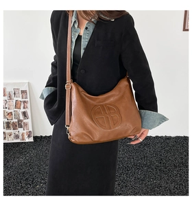 Brown lychee leather tote bag with embossed logo shown on model for daily lifestyle wear