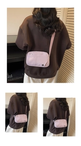 Three-way view of light purple nylon crossbody bag showing the adjustable strap on a model