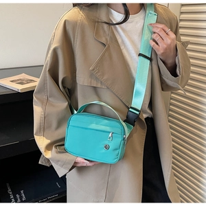 Gros plan du sac à bandoulière en nylon vert menthe avec sangle réglable sur mannequin