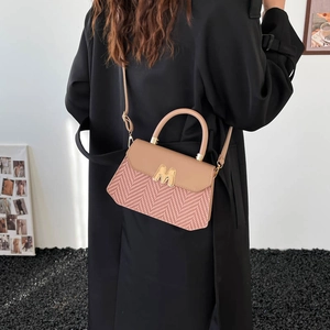 Modieuze strooien crossbodytas met roze visgraatpatroon en gouden M-gesp detail