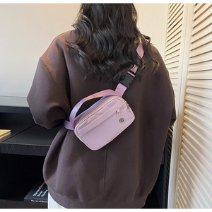 Détail de la boucle noire réglable et de la large bandoulière du sac nylon lilas