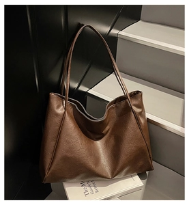 Close-up of deep brown oil-wax leather texture on a large capacity tote bag