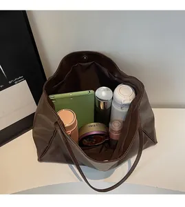Spacious interior of large brown PU leather tote bag showing items for daily commuting