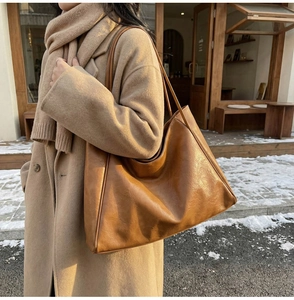 Detail of caramel brown PU leather tote bag with shoulder straps for winter commute