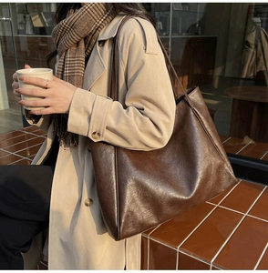 Detail of vintage glossy faux leather tote bag in dark brown for daily autumn commute