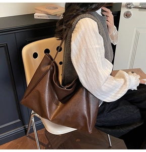 Detailed texture of dark coffee vintage PU leather on a large slouchy hobo tote bag