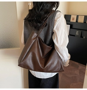 Detail of dark brown faux leather tote bag showing soft texture and spacious capacity
