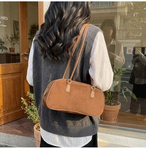 Retro caramel suede baguette shoulder bag with slim straps shown in a lifestyle setting