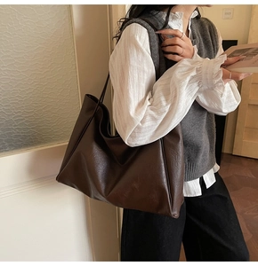 Detail view of large vintage brown PU leather tote bag with soft texture and long strap