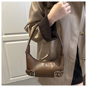 Detailed view of brown hobo bag with silver buckle straps and sleek zipper closure