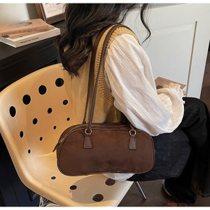 Brown suede shoulder bag shown with an elegant retro outfit and cream background