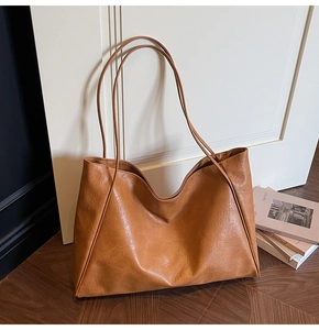 Close-up of vintage brown tote bag featuring soft pleated faux leather and long straps