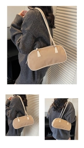 Detail of khaki shoulder bag with white leather trim and minimalist rectangular design
