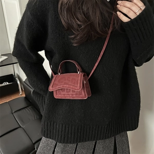 Chic dark red mini square crossbody bag worn over a black sweater for a stylish look