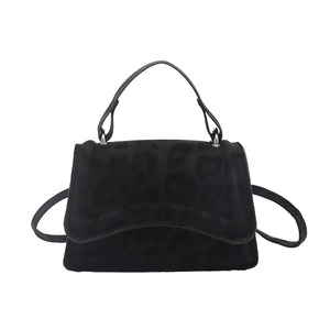 Minimalist black square handbag with leopard print flap and adjustable crossbody strap