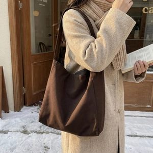 Borsa tote in tela marrone retrò per scuola e ufficio mostrata in una scena di strada invernale