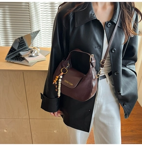 Borsa hobo a mezzaluna in pelle marrone con logo dorato e dettaglio charm in legno