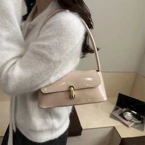 Sac baguette français en cuir verni beige avec un fermoir tournant doré élégant