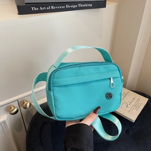 Lightweight Tiffany blue nylon crossbody bag with metal logo and adjustable strap