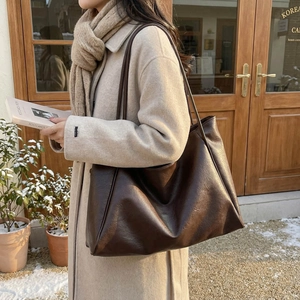 Large dark brown vintage PU leather tote bag shown in a cozy outdoor cafe setting