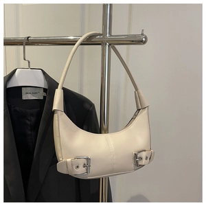 Detail of cream white crescent hobo bag with silver buckle and smooth faux leather texture