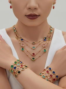 Close-up of a model wearing a luxury 18k gold plated colorful crystal jewelry set
