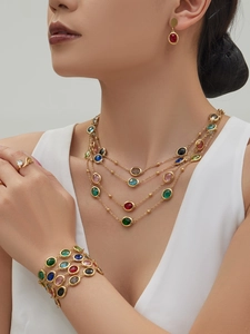 Close-up of gold stainless steel jewelry set with multi-colored faceted gemstones