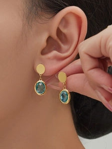 Macro shot of 18k gold plated drop earrings with faceted sky blue oval glass stones