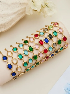 Detailed view of colorful oval gemstones on gold chains arranged on a jewelry display