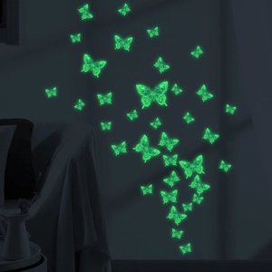 Glow-in-the-dark butterfly wall stickers with luminous green effect in a cozy bedroom