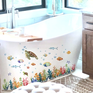 Detail view of waterproof sea turtle and tropical fish stickers on a white bathtub side