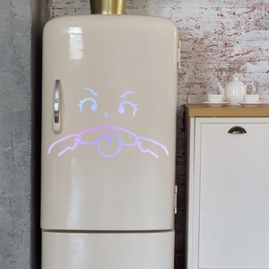Close-up of cute cartoon emoji wall sticker on vintage fridge in kitchen decor