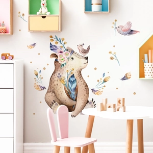 Close-up of a cartoon bear and bird wall stickers in a cozy children room setting