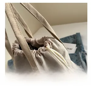 Détail du cabas beige avec fermeture à cordon et motif d'ours imprimé