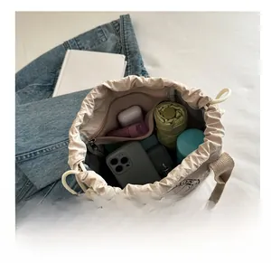 Vue intérieure du sac seau étanche beige avec téléphone parapluie et bouteille d'eau