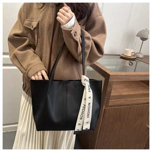 Dettaglio della borsa tote nera con cinturino beige e design capiente ed elegante