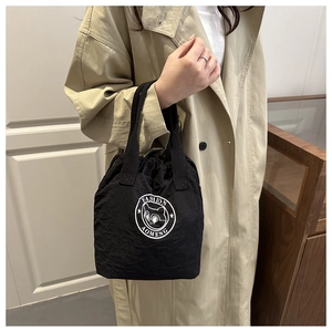 Détail du sac seau noir imperméable avec cordon et logo de chat à la mode