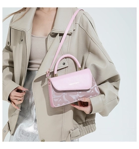 Détail du sac en cuir rose avec texte de mode et base à motifs abstraits