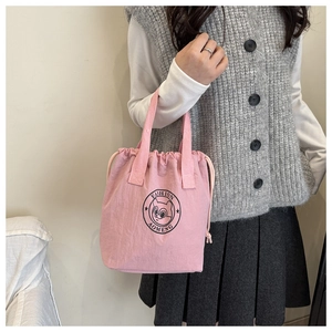 Pink waterproof bucket bag with drawstring and cartoon bear print shown on a model
