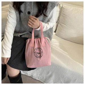 Pink waterproof drawstring bucket bag with squirrel print held by a model in a home setting