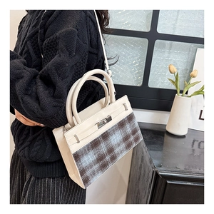 Detail showing elegant beige leather and plaid stitching with silver metal buckle