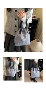 Detail of grey waterproof drawstring bucket bag featuring a white bear logo and blue handles