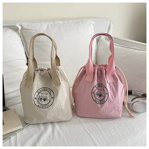 Detail of waterproof drawstring bucket bags in beige and pink with fashion logo print