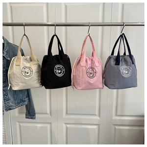 Détail de quatre sacs seaux en nylon avec imprimés panda et fermetures par cordon serrage