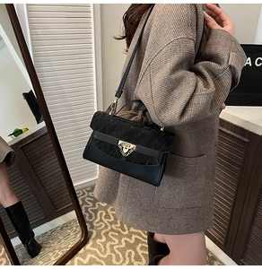Detail of black patchwork shoulder bag showing textured jacquard and smooth leather finish