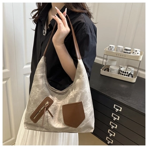 Detail of vintage canvas tote bag with brown leather pockets and shoulder strap style