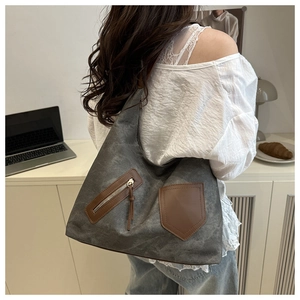 Hobo tote bag in grey canvas with brown leather pockets shown in a lifestyle office setting